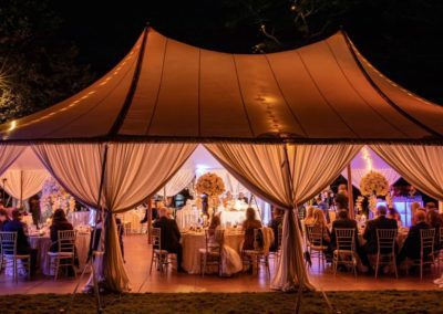 A sailcloth wedding tent lit up at night