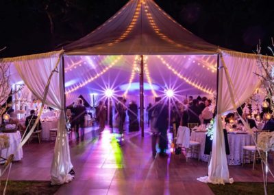 A sailcloth wedding tent lit up for a wedding at night