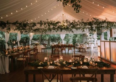 a rustic wedding tent, with tables and chairs set up inside